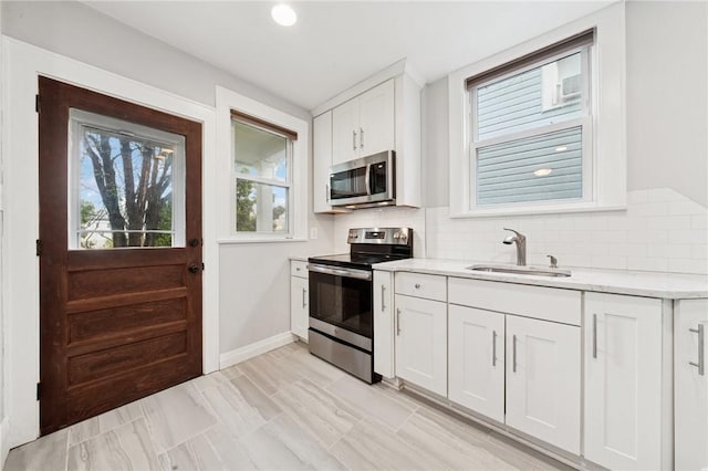 1110 Illinois Ave, Dormont, PA 15216 - kitchen with stainless steel appliances, a sink, backsplash, white cabinetry, and recessed lighting