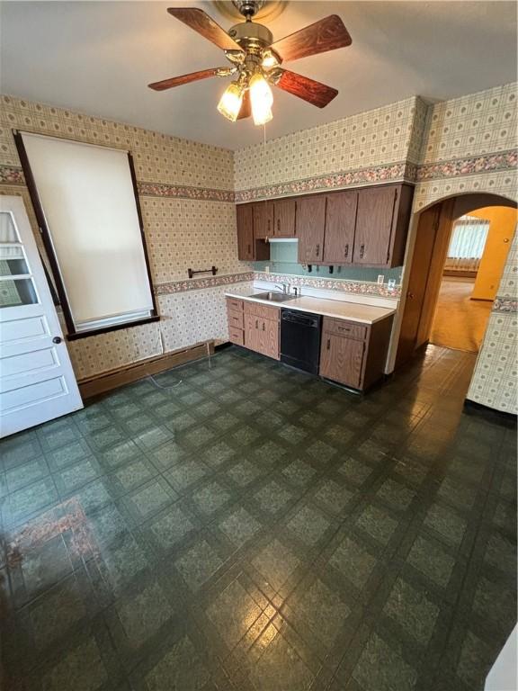 7027 Blackhawk St, Swissvale, PA 15218 - kitchen featuring wallpapered walls, dishwasher, light countertops, a ceiling fan, and arched walkways
