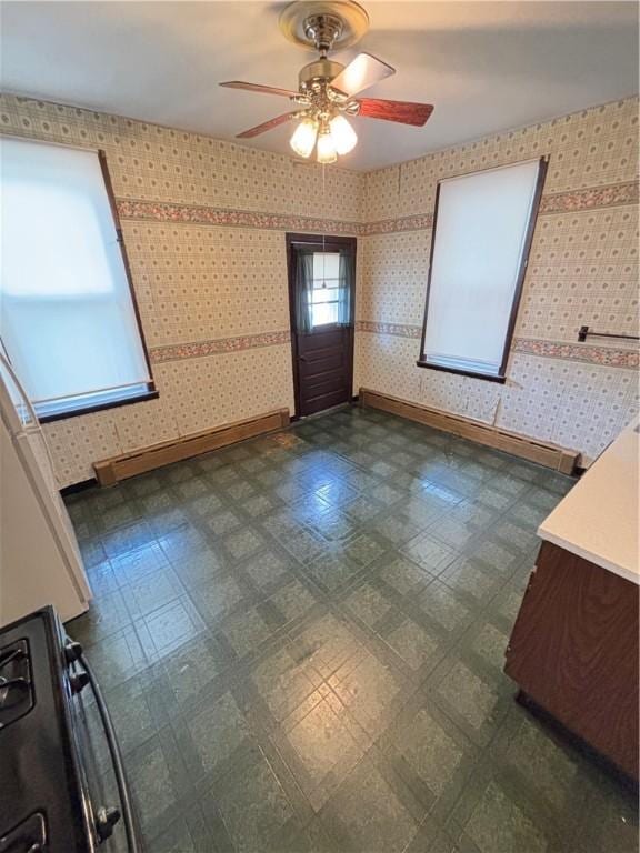 7027 Blackhawk St, Swissvale, PA 15218 - unfurnished dining area with dark flooring, a baseboard heating unit, a ceiling fan, and baseboards