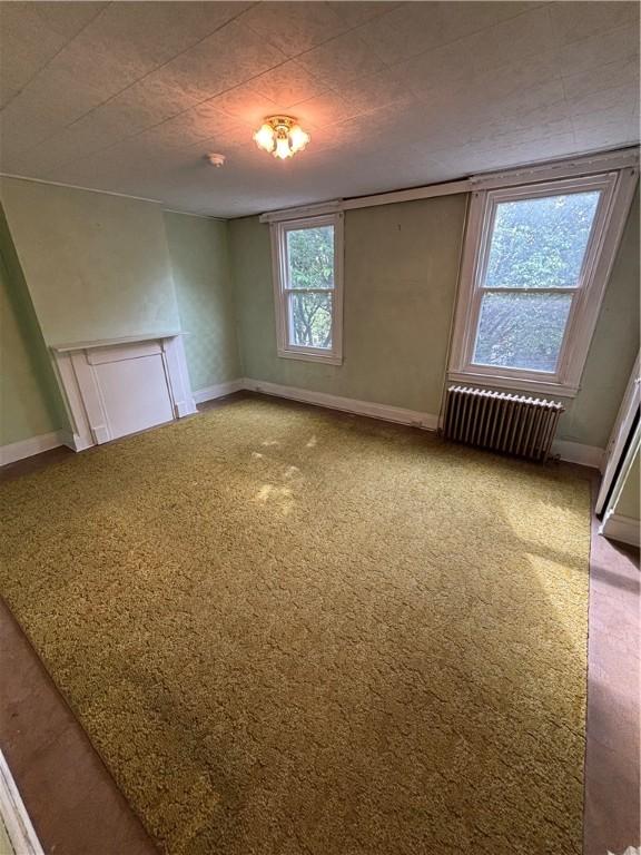 7027 Blackhawk St, Swissvale, PA 15218 - carpeted empty room featuring radiator and baseboards