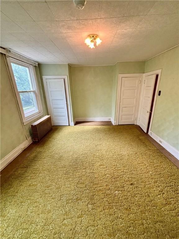 7027 Blackhawk St, Swissvale, PA 15218 - carpeted empty room featuring radiator and baseboards