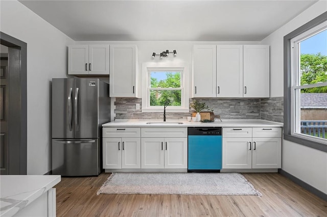 1815 Ohio Ave, White Oak, PA 15131 - kitchen with freestanding refrigerator, dishwashing machine, a sink, light countertops, and light wood-style flooring
