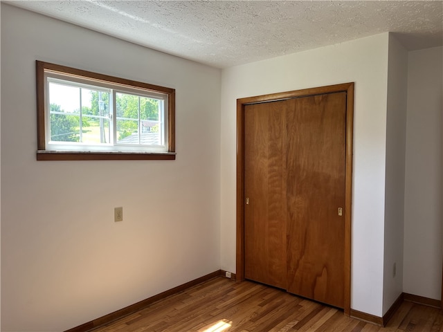 100 Rohaley Ln, Menallen Twp, PA 15480 - unfurnished bedroom featuring wood finished floors, baseboards, a closet, and a textured ceiling