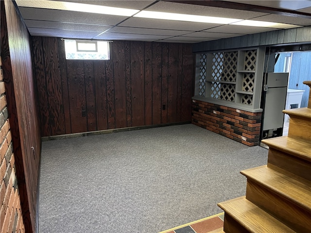 100 Rohaley Ln, Menallen Twp, PA 15480 - basement featuring stairs, wooden walls, carpet flooring, freestanding refrigerator, and a paneled ceiling