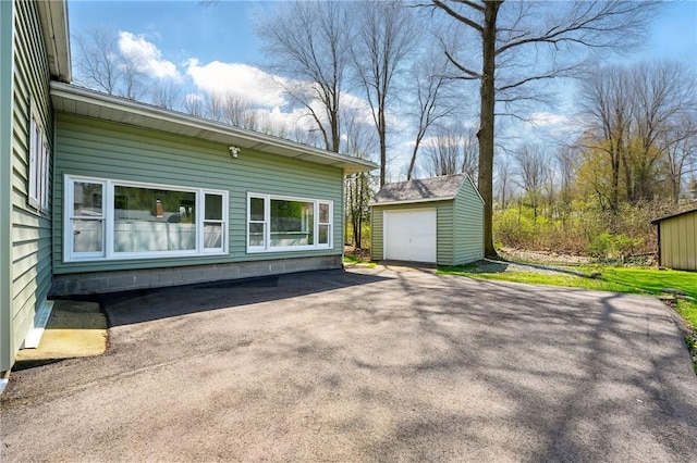 385 Vogan Dr, Mercer Boro Mer, PA 16137 - view of home's exterior featuring an outdoor structure, asphalt driveway, and a detached garage