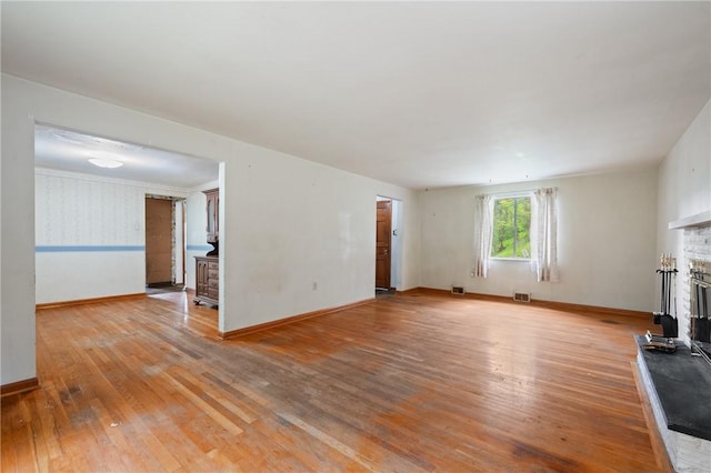 173 Mcintyre Rd, Ross Twp, PA 15237 - unfurnished living room with a fireplace with raised hearth, light wood-style flooring, and baseboards