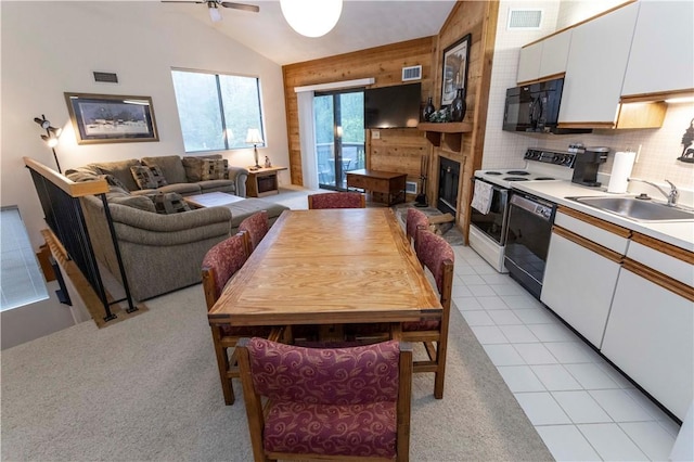 W1 Sunridge Dr, Seven Springs Resort, PA 15622 - dining room featuring vaulted ceiling, a glass covered fireplace, ceiling fan, wooden walls, and light colored carpet