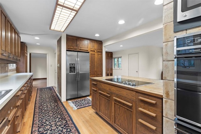 1 Robin Rd, Squirrel Hill, PA 15217 - kitchen with appliances with stainless steel finishes, light wood-type flooring, recessed lighting, tile countertops, and brown cabinetry