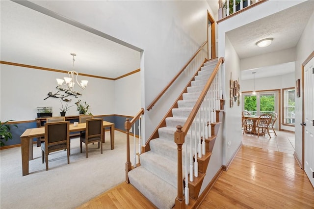 1016 Noble Pine Ct, Trafford, PA 15085 - staircase with wood finished floors, a chandelier, and baseboards