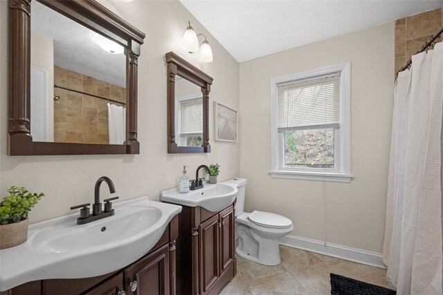 600 Camp Meeting Rd, Leet Twp, PA 15143 - full bath featuring two vanities, toilet, curtained shower, and baseboards