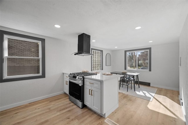2874 Midland St, Brookline, PA 15226 - kitchen with wall chimney range hood, gas range, a peninsula, light wood-style flooring, and baseboards