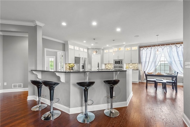 1272 Mcewen Rd, Cecil, PA 15317 - kitchen featuring stainless steel appliances, a kitchen breakfast bar, glass insert cabinets, recessed lighting, and ornamental molding