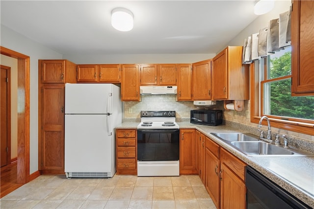 406 Maple Dr, Irwin, PA 15617 - kitchen with black appliances, under cabinet range hood, a sink, brown cabinetry, and backsplash