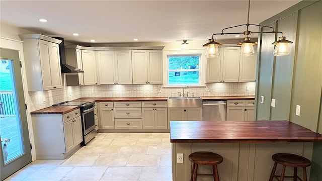 102 Green Vista Dr, Ohio Twp, PA 15237 - kitchen featuring wood counters, appliances with stainless steel finishes, a kitchen bar, wall chimney exhaust hood, and tasteful backsplash