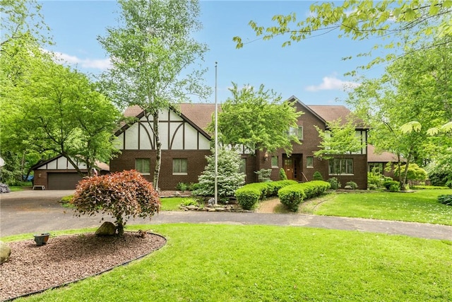 138 Presnar Dr, Neshannock Twp, PA 16105 - english style home featuring asphalt driveway, a garage, a front yard, and brick siding