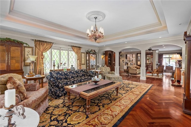 138 Presnar Dr, Neshannock Twp, PA 16105 - living room featuring ornate columns, arched walkways, a tray ceiling, a chandelier, and crown molding