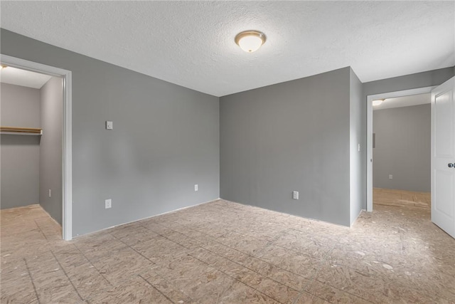 677 Fairlane Blvd, New Galilee, PA 16141 - unfurnished bedroom featuring a textured ceiling, a walk in closet, and a closet