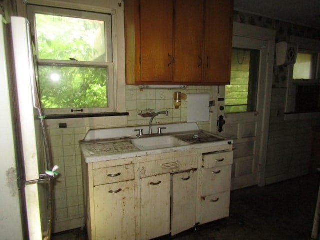 445 4th St, Freedom, PA 15042 - kitchen with a sink, light countertops, freestanding refrigerator, tile walls, and decorative backsplash