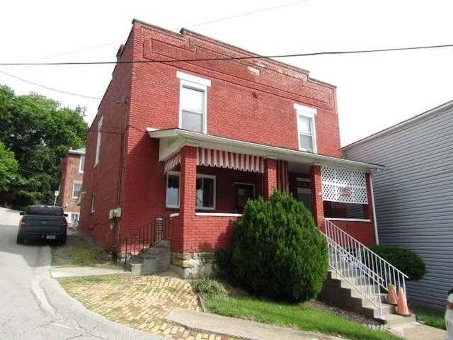 1214 1/2 3rd St, Mckees Rocks, PA 15136 - view of front of home featuring brick siding, stairway, and a porch