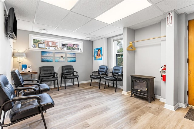 1900 Ardmore Blvd, Forest Hills Boro, PA 15221 - living area with a drop ceiling, light wood-style flooring, a wood stove, baseboards, and plenty of natural light