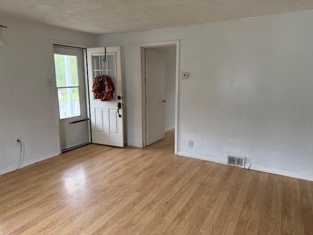 15 Miner Ave, Bentleyville, PA 15314 - empty room with light wood-type flooring, baseboards, and a textured ceiling