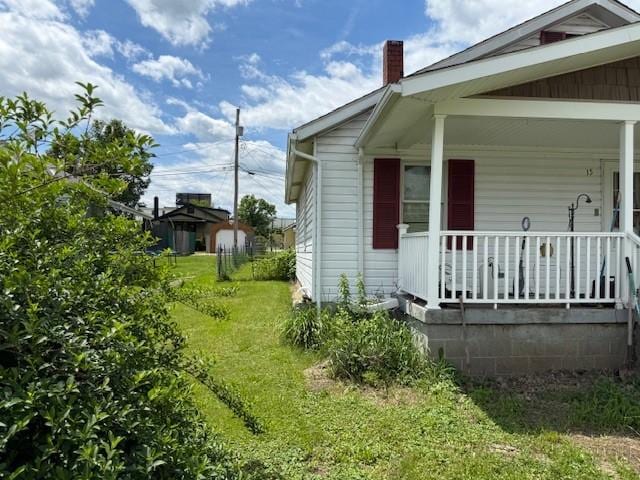 15 Miner Ave, Bentleyville, PA 15314 - view of side of property with a chimney, a porch, and a lawn