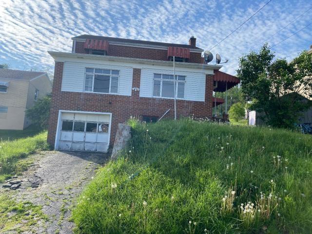 923 7th Ave, Elizabeth Twp/Boro, PA 15037 - view of front of house featuring asphalt driveway, brick siding, a garage, and a chimney