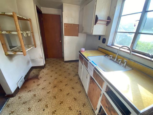 923 7th Ave, Elizabeth Twp/Boro, PA 15037 - kitchen featuring light floors, baseboards, white cabinetry, a sink, and light countertops