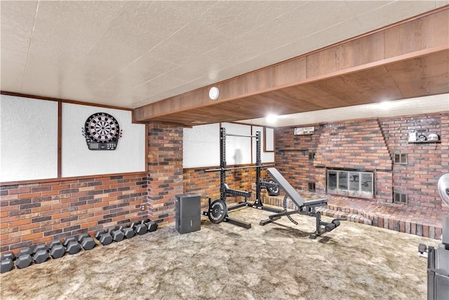 536 Hopewell Rd, Luzerne Twp, PA 15433 - exercise area with carpet floors, a brick fireplace, brick wall, and a textured wall