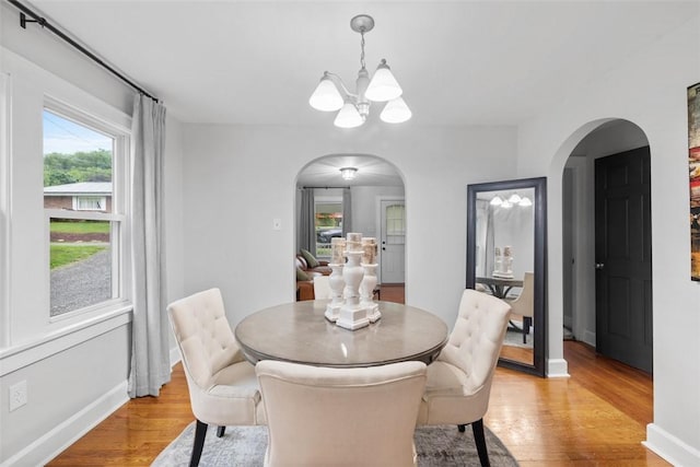 190 Elm St, Daugherty Twp, PA 15066 - dining area with arched walkways, a chandelier, light wood-type flooring, and baseboards