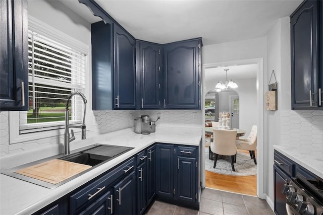 190 Elm St, Daugherty Twp, PA 15066 - kitchen with a sink, tasteful backsplash, light countertops, blue cabinets, and tile patterned flooring