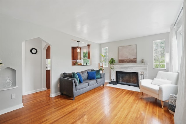 9440 Peebles Rd, Mccandless, PA 15101 - living room with light wood finished floors, arched walkways, a glass covered fireplace, and baseboards
