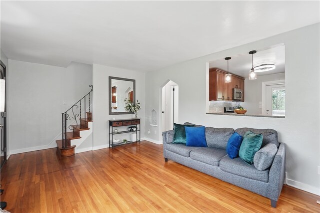 9440 Peebles Rd, Mccandless, PA 15101 - living area featuring light wood-style floors, stairs, baseboards, and arched walkways