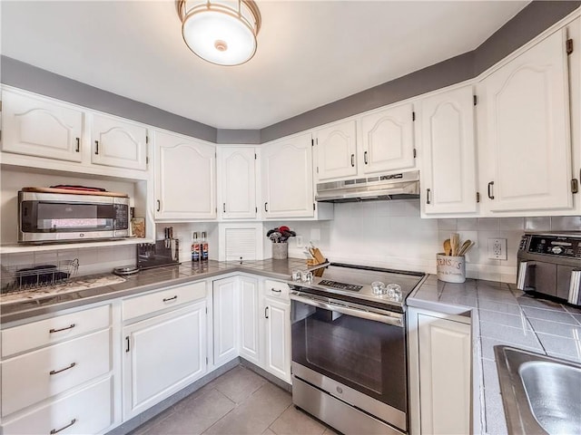 3181 Mellott Rd, Baldwin Boro, PA 15227 - kitchen with stainless steel appliances, under cabinet range hood, white cabinetry, tasteful backsplash, and light tile patterned flooring