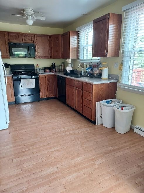 1046 Elicker Rd, Plum Boro, PA 15068 - kitchen featuring black appliances, a sink, light countertops, light wood-type flooring, and ceiling fan