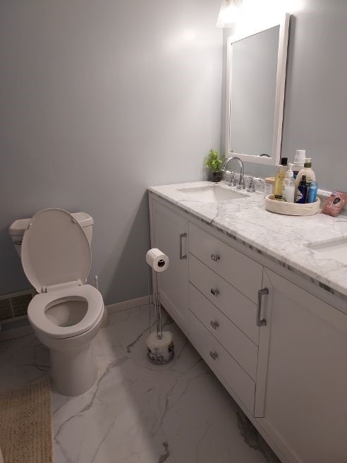1046 Elicker Rd, Plum Boro, PA 15068 - bathroom with marble finish floors, double vanity, toilet, and baseboards