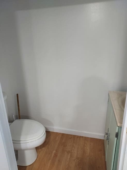 1046 Elicker Rd, Plum Boro, PA 15068 - bathroom featuring vanity, toilet, wood finished floors, and baseboards