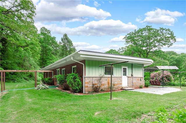 541 W Danville Rd, Oakland Twp, PA 16025 - view of front of home featuring board and batten siding, a front lawn, a patio area, and stone siding
