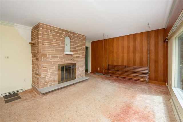 541 W Danville Rd, Oakland Twp, PA 16025 - unfurnished living room featuring wooden walls, baseboard heating, a stone fireplace, crown molding, and carpet