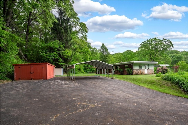 541 W Danville Rd, Oakland Twp, PA 16025 - view of front of home featuring driveway, a detached carport, a front yard, and stone siding