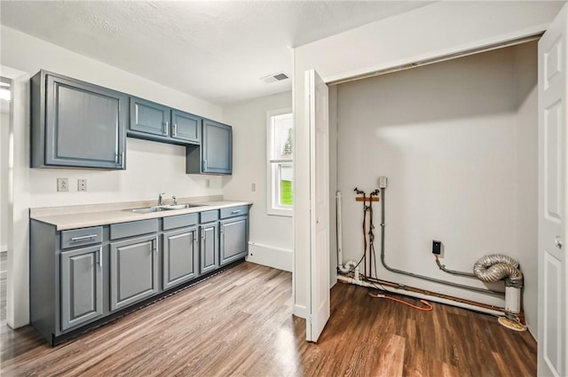 256 Marshall St, Hermitage, PA 16148 - kitchen featuring a sink, wood finished floors, light countertops, and gray cabinets