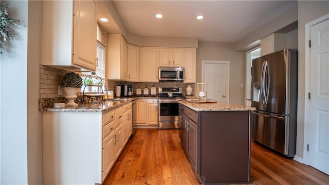 104 Cherokee Ct, Buffalo Twp But, PA 16229 - kitchen featuring stainless steel appliances, a kitchen island, light stone countertops, wood finished floors, and recessed lighting