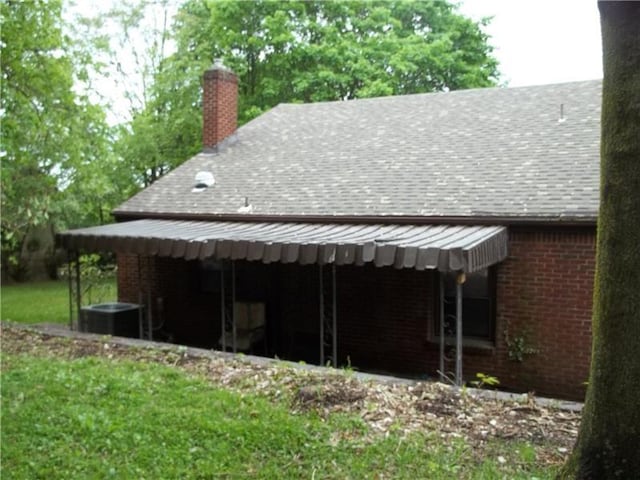 1545 Cooper Ave, Brighton Heights, PA 15212 - view of property exterior featuring cooling unit, roof with shingles, a chimney, and brick siding
