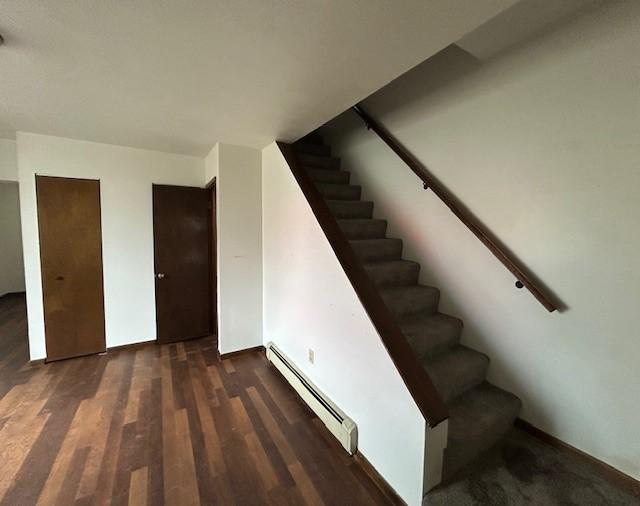 735 Park Ave, Johnstown, PA 15902 - stairway with baseboard heating, wood finished floors, and baseboards