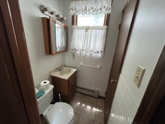735 Park Ave, Johnstown, PA 15902 - bathroom featuring baseboard heating, toilet, vanity, and tile patterned flooring