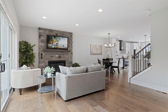 325 Augusta St, Mt Washington, PA 15211 - living area with stairway, light wood finished floors, a fireplace, recessed lighting, and a chandelier