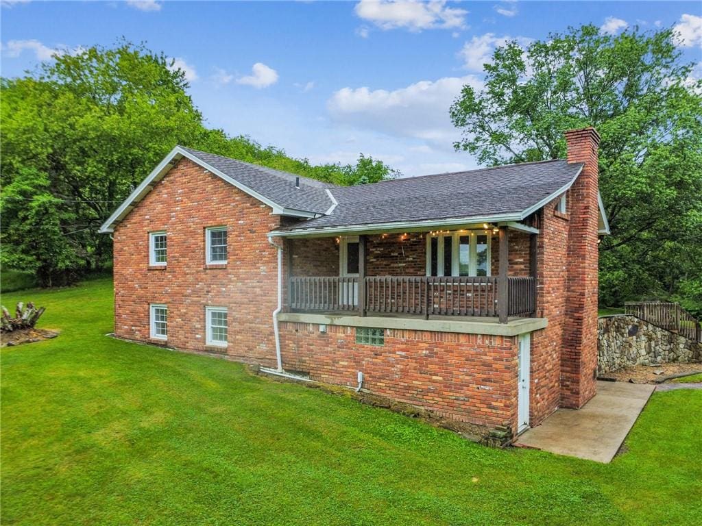 452 Cadogan Slate Lick Rd, North Buffalo Twp, PA 16201 - view of front facade with a front lawn, a chimney, brick siding, and roof with shingles