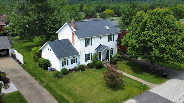 115 Orchard Ave, Rostraver, PA 15012 - view of front facade featuring a shingled roof, a chimney, central air condition unit, a front yard, and a view of trees