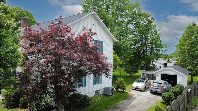115 Orchard Ave, Rostraver, PA 15012 - view of side of home with driveway, an outbuilding, a chimney, and central air condition unit