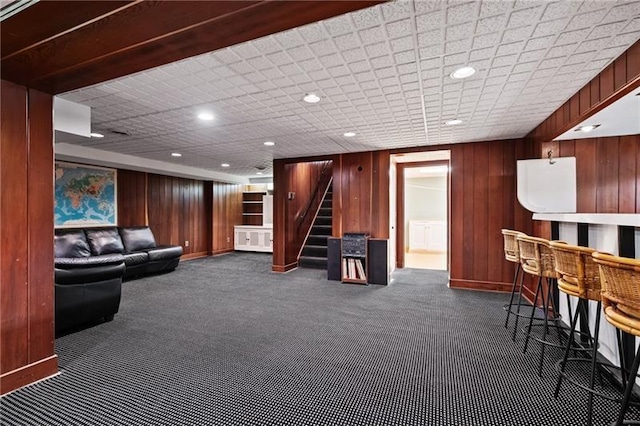 6820 Edgerton, Point Breeze, PA 15208 - living area featuring dark colored carpet, stairs, a dry bar, wooden walls, and baseboards